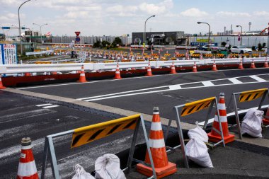 Turuncu trafik konileri inşaat bariyerleri yakınındaki yolu kapatıyor