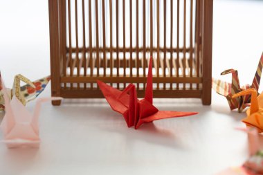 Renkli origami turnaları ahşap yapının yanında dinleniyor