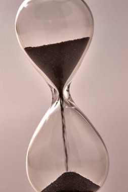 İçinde kum olan kum saatinin yakın görüntüsü.