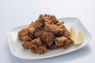 Beyaz tabakta limonlu kızarmış tavuk kanadı yığını