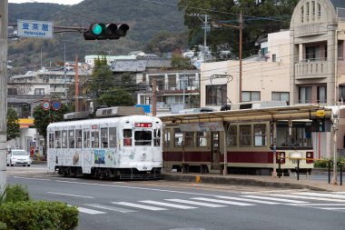 Tramvay ticari Japon caddesinde ilerlerken gün ışığı renkli arabayı aydınlatıyor..