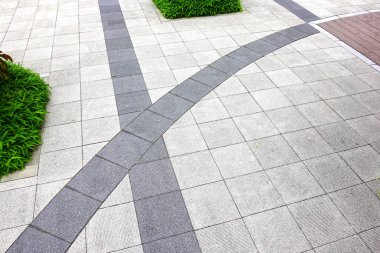 Yeşil çimen ve kiremitlerle kesişen Paved geçidi