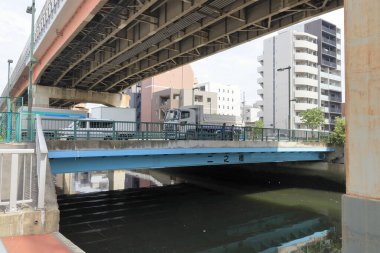 Japon şehrinde köprünün altından akan nehir.