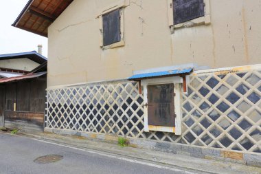 Geometrik desenli duvar ve küçük pencereli eski bina