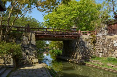 Kanal üzerinde köprü ve baharda yeşil ağaçların manzarası. Japonya
