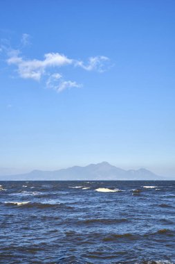 Güzel deniz manzarası ve arka planda dağlar.