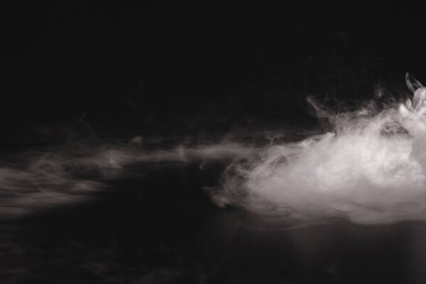 white smoke in the dark background. abstract texture of fog.                   