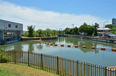 Sakin su deposu kentsel binaların yanındaki mavi gökyüzünü yansıtıyor.