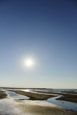 Kumsalda gün batımı ve mavi gökyüzü