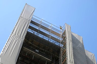 Mavi gökyüzüne karşı koruyucu kumaşla kaplı yapı.