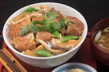 Kızarmış tavuk sebze kasesinin üzerinde dinleniyor.