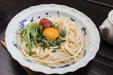 Çiğ yumurta sarısı ile kaplanmış taze udon erişteleri susam tohumları