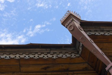 Ahşap pencereli eski bir binanın ön cephesi.