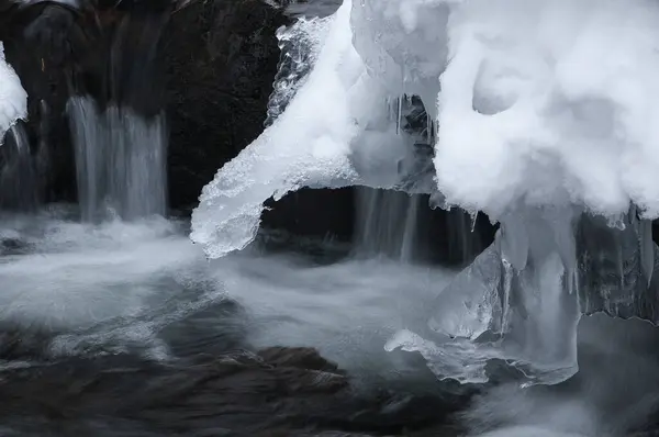 a waterfall with ice and water flowing over it