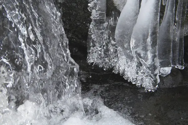 a waterfall with ice and icicles hanging from it