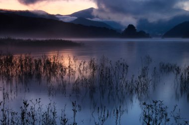 Arka planda dağ olan bir göl.