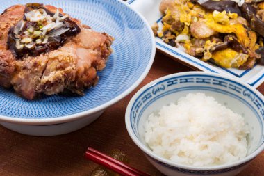 Bir kase pirinç ve bir kase etle dolu bir masa.