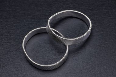 Siyah zemin üzerindeki parlak metal halkaların yakın plan görüntüsü