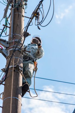 Çalışan erkek elektrikçi ve mavi gökyüzü