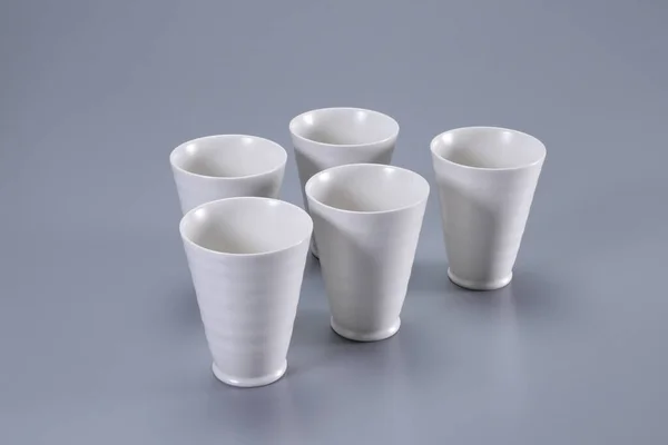 empty white plastic cups on gray background.