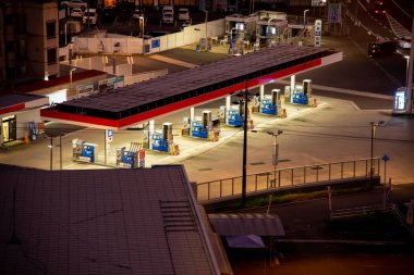 Geceleri çok sayıda yakıt pompası gösteren boş bir benzin istasyonu.