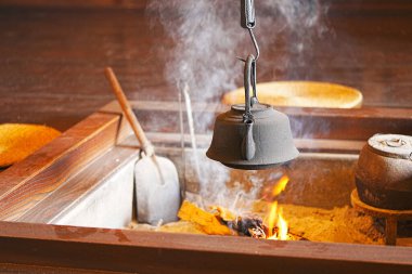 Eski tip çaydanlık şöminede yanan odunların üzerinde ısıtılıyor.