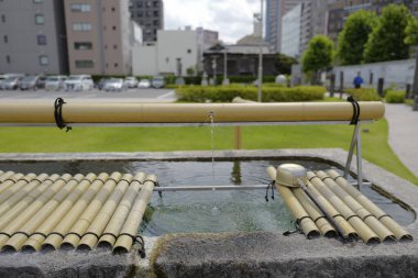Japonya 'da bir tapınağın önünde namaz kılmadan önce ellerini temizlemek için Japon bezi.