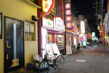 Modern Japon şehrinin caddesindeki aydınlık dükkanlar 