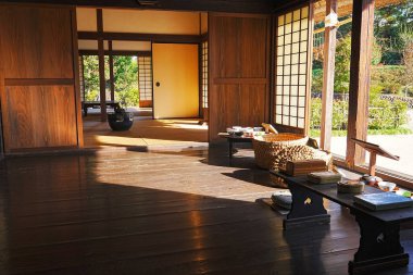 Koyu Ahşap Döşemeleri, Kaygan Kapıları ve Aydınlatıcı Doğal Çay Seremonisi Nesneleri olan Geleneksel Japon Odası