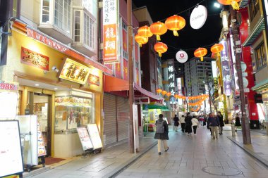 Modern Japon şehrinin caddesindeki aydınlık dükkanlar 