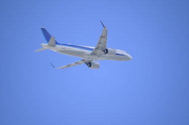Mavi gökyüzünde uçan uçak 