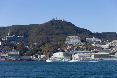 Japonya 'daki Nagasaki Limanı, hareketli limana kenetlenmiş çeşitli tekne ve teknelerin manzaralı manzarasına sahiptir. 