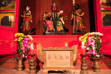 Küçük bir tapınakta Çin Tanrıları, Çiçekler ve Mumlarla sunak