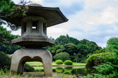 Japonya 'da taş kulesi ve ağaçları olan Japon bahçesi.. 