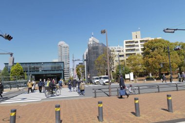 Bir Japon şehrinde yaya geçidi ve sokak manzarası ile meşgul.