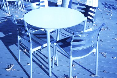 Açık teras kafesinde sandalyeli yuvarlak masa.