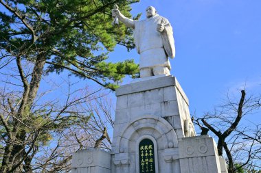 Güneşli bir günde Japon şehrindeki taş anıt.