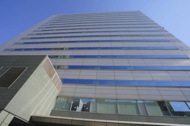 Pencereleri ve ofis binasının camdan duvarı olan modern bir iş binası.