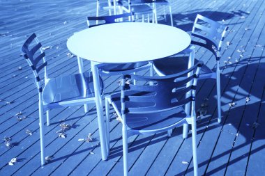 Açık teras kafesinde sandalyeli yuvarlak masa.