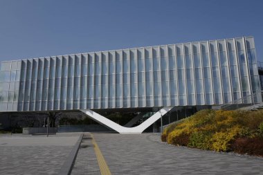 Dikey yüzgeçleri ve manzaralı çevresi olan modern cam bina.