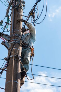 Çalışan erkek elektrikçi ve mavi gökyüzü