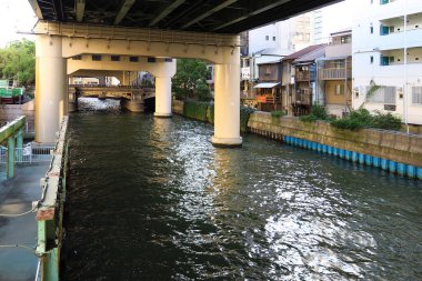 Yükseltilmiş otobanın altından geçen şehir kanalı konut binalarının yanında.