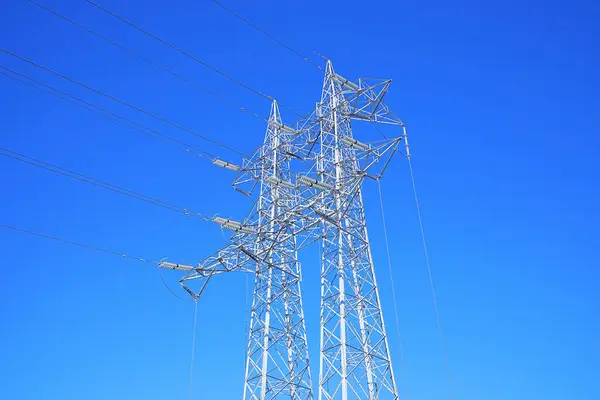 Yüksek Voltajlı Elektrik Hatları Mavi Gökyüzü Arka Planında Elektrik Direği — Stok fotoğraf