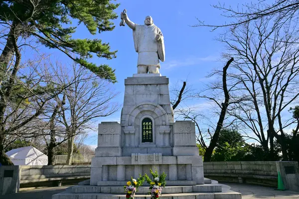 Güneşli bir günde Japon şehrindeki taş anıt.