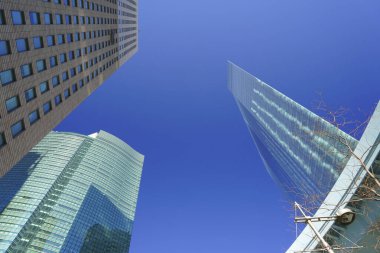 Güneşli bir günde modern şehir mimarisi. Gökdelenlerin mavi gökyüzüne bakışı