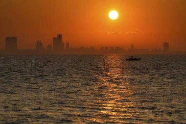 Şehir manzarası gökyüzü ve deniz üzerinde gün batımı