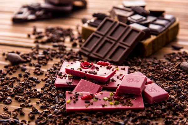 close up of pink chocolate pieces on wooden background