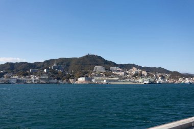 Dağlarla çevrili Nagasaki Limanı, tekneler ve liman manzarası  