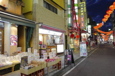 Modern Japon şehrinin caddesindeki aydınlık dükkanlar 