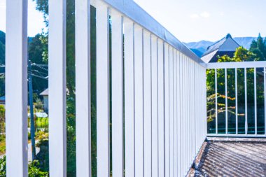 Kırsal ve dağlık manzaralı bir terasın demir parmaklıkları.